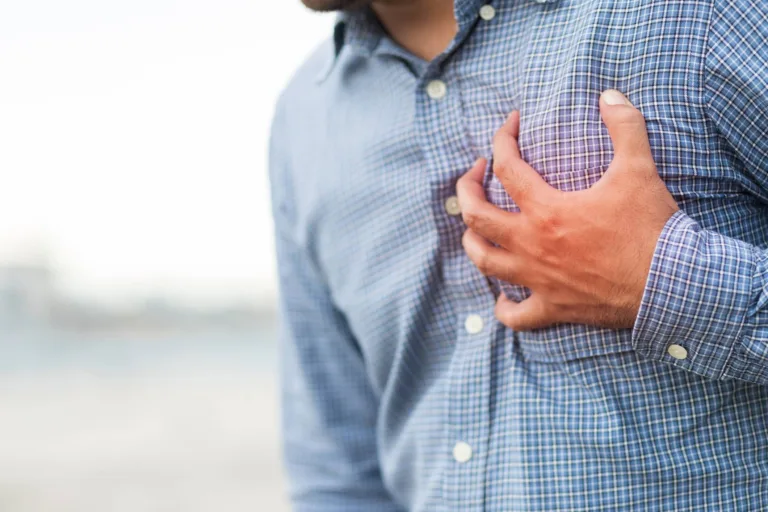 Hand of a man squeezing his heart for having chest pain